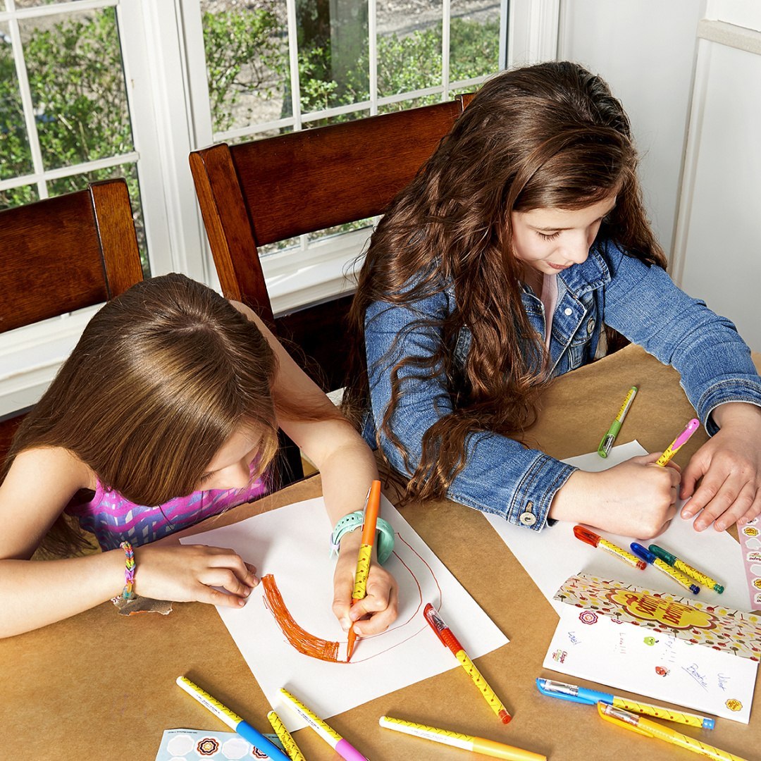 Dwie dziewczynki rysujące przy stole flamastrami zapachowymi Chupa Chups BV JACOB COMPANY