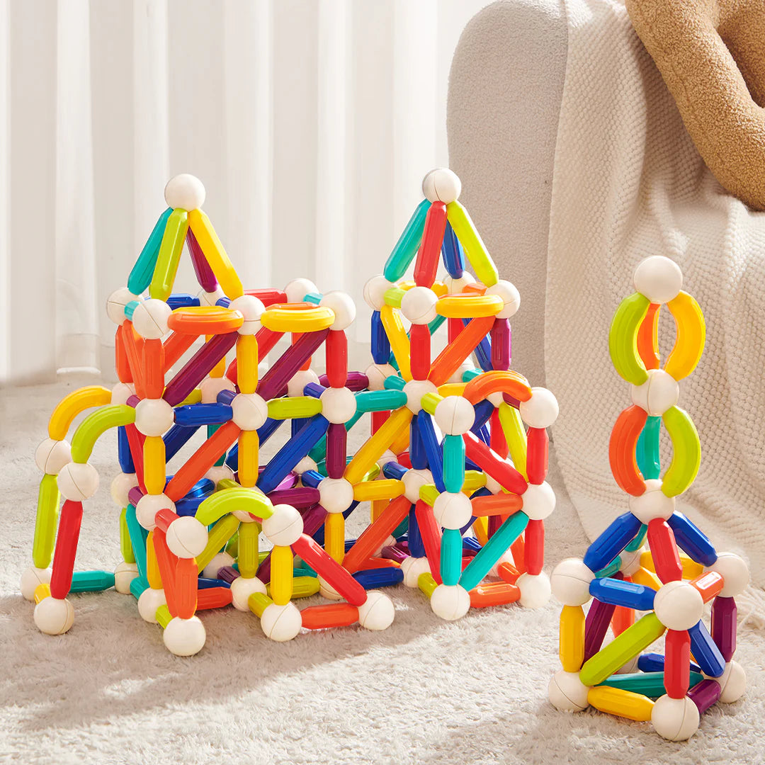 Kolorowe magnetyczne pałeczki konstrukcyjne ułożone w geometryczne kształty na podłodze