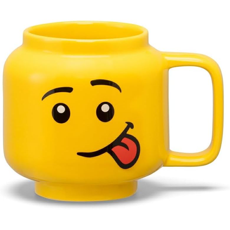 Żółty kubek LEGO głowa chłopiec z wyrazem języka na wesołej twarzy do picia kawy lub herbaty