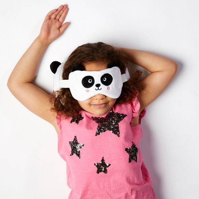 Pluszowa poduszka podróżna panda w formie maski na oczy na dziewczynce w różowej bluzce