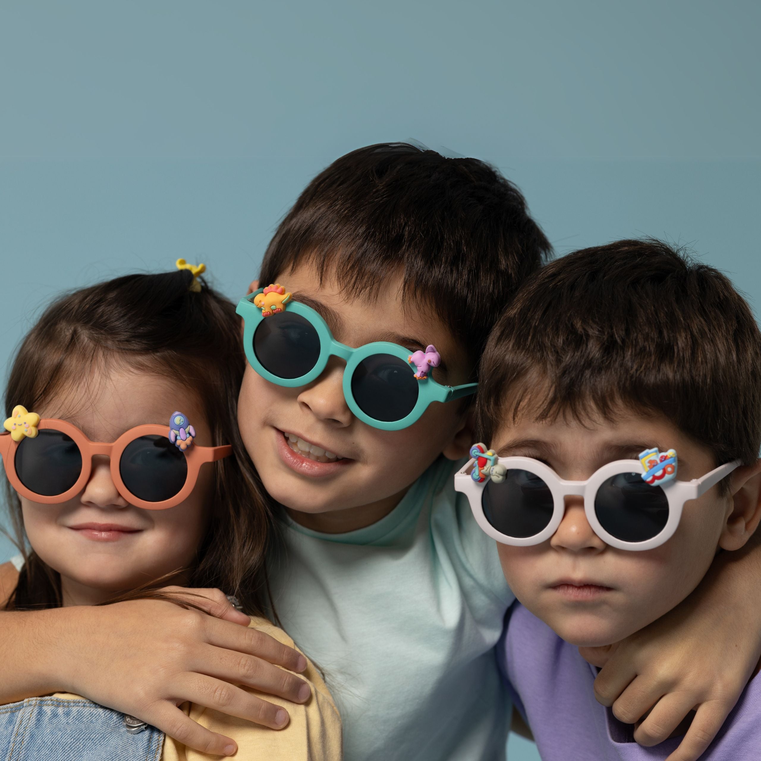 Trójka dzieci noszących kolorowe okulary przeciwsłoneczne dla dzieci z ozdobami na oprawkach