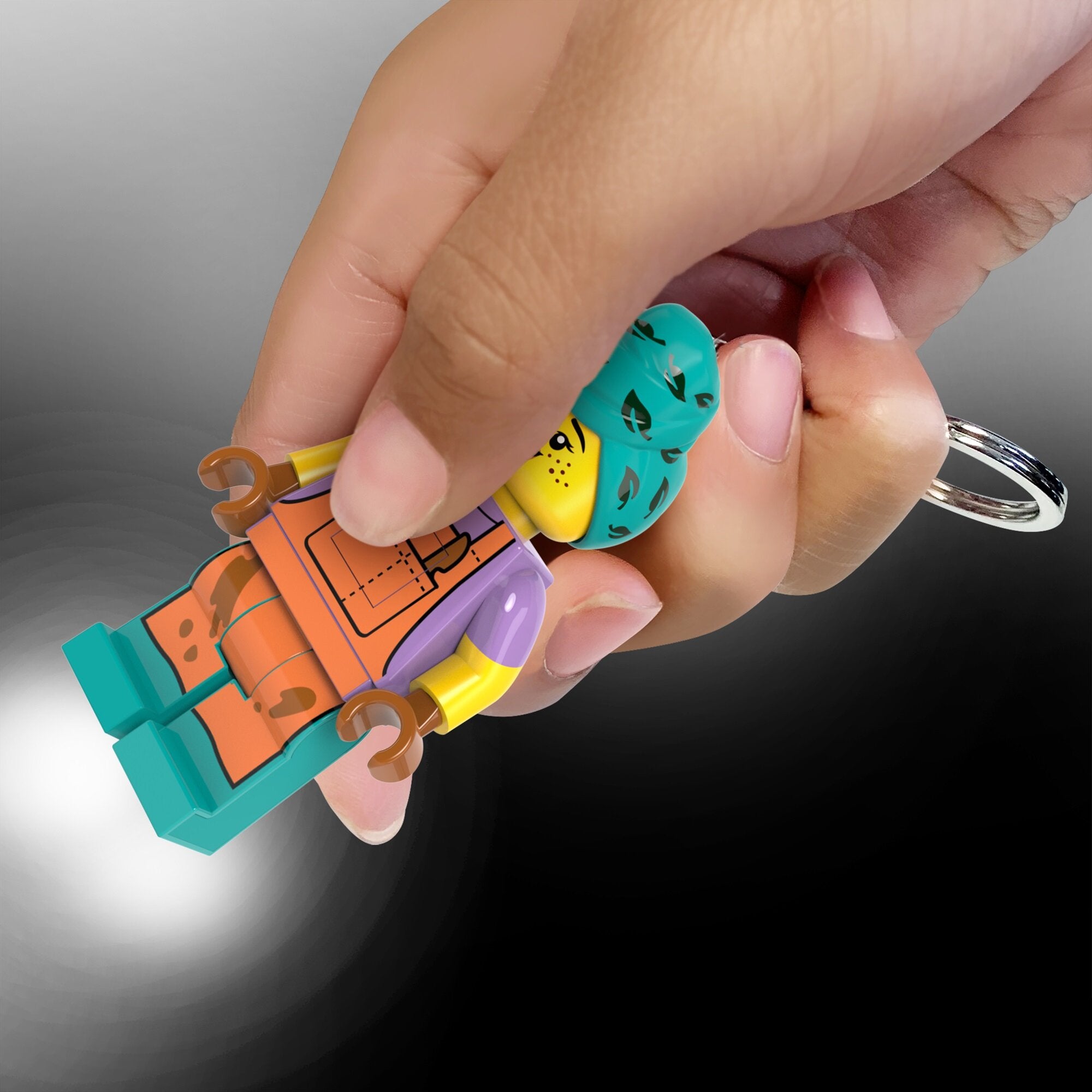 Brelok z latarką LEGO Garncarka trzymany w dłoni z włączoną lampką LED