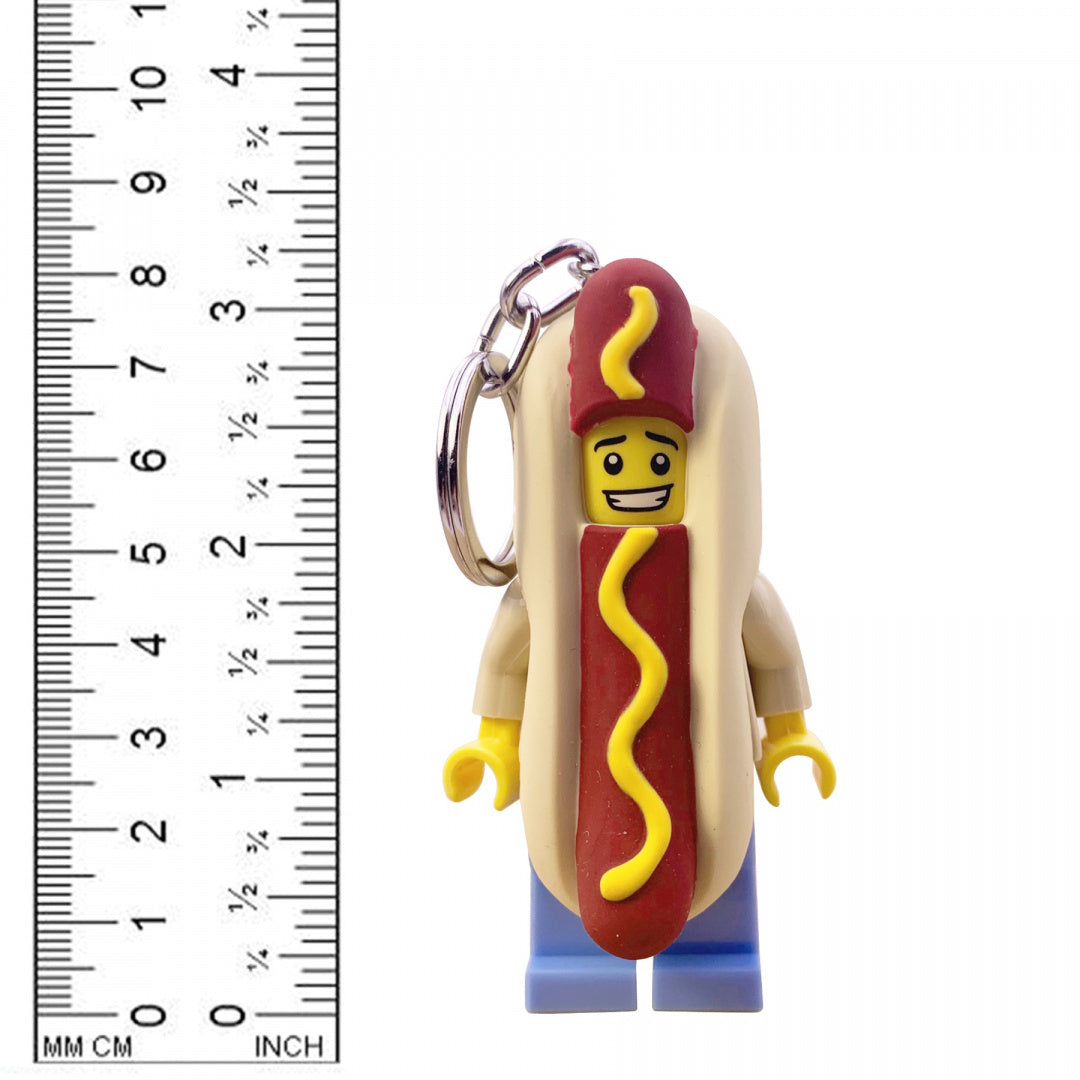 Brelok LEGO z latarką przedstawiający postać w kostiumie hot doga na białym tle z linijką