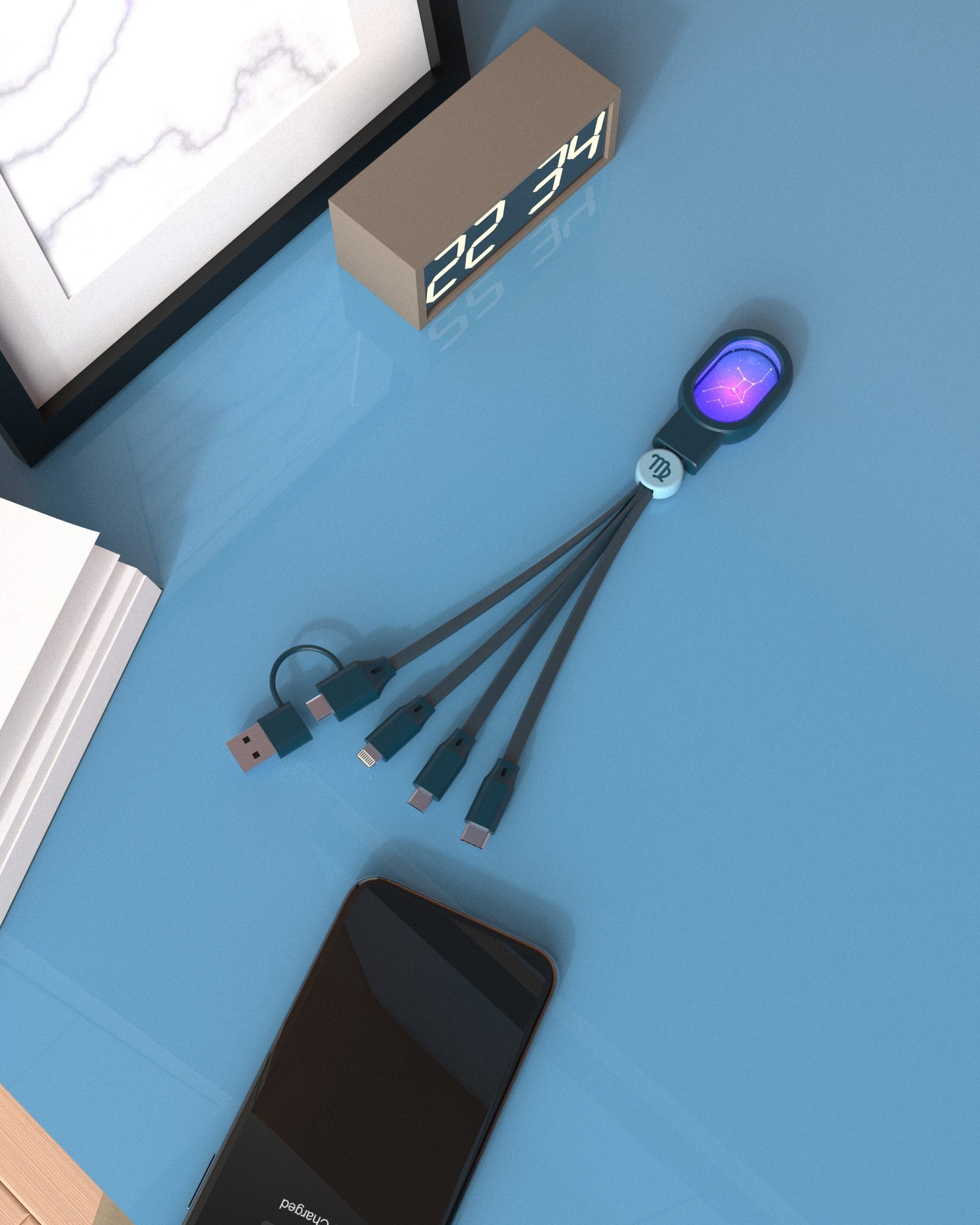 kabel 5 w 1 zodiak strzelec z wieloma końcówkami USB na niebieskim blacie obok smartfona i zegara