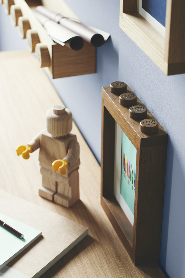 Drewniana ramka LEGO na zdjęcia z charakterystycznymi klockami LEGO na górze ramki