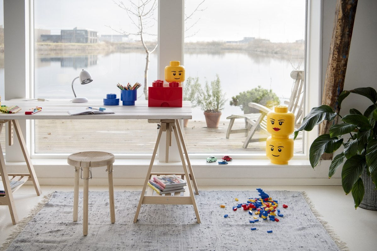 Pojemnik LEGO głowa dziewczynka w formie kolorowego pojemnika do przechowywania klocków LEGO w jasnym pokoju