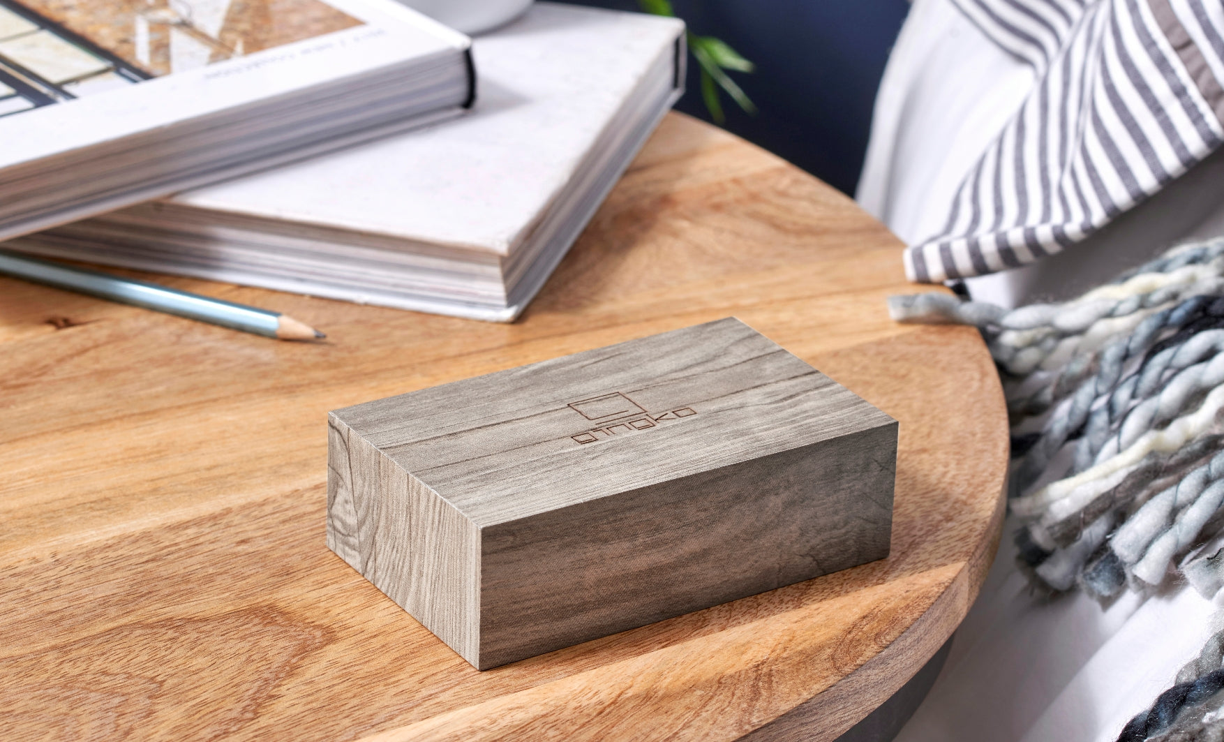Budzik flip click popiel w kształcie drewnianej kostki na drewnianym stole obok książek i ołówka