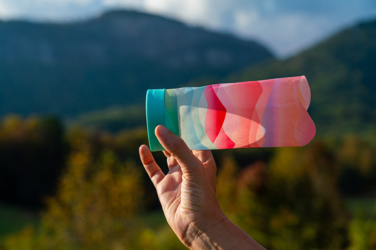 Rzutka Waboba Airlyft w kolorze różowo-niebieskim trzymana w dłoni z górskim tłem