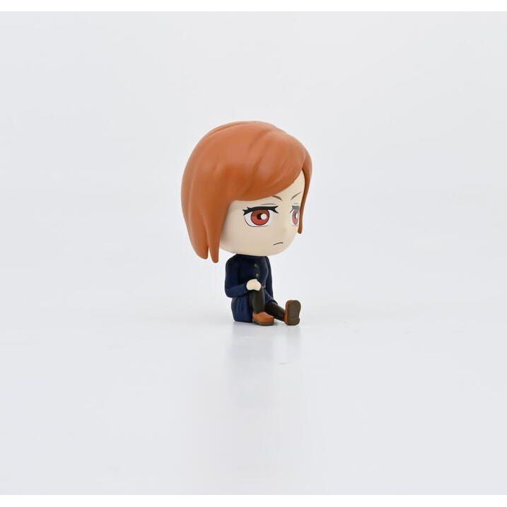 Figurka bobble head Jujutsu Kaisen z rudymi włosami i niebieskim ubraniem siedząca na białym tle