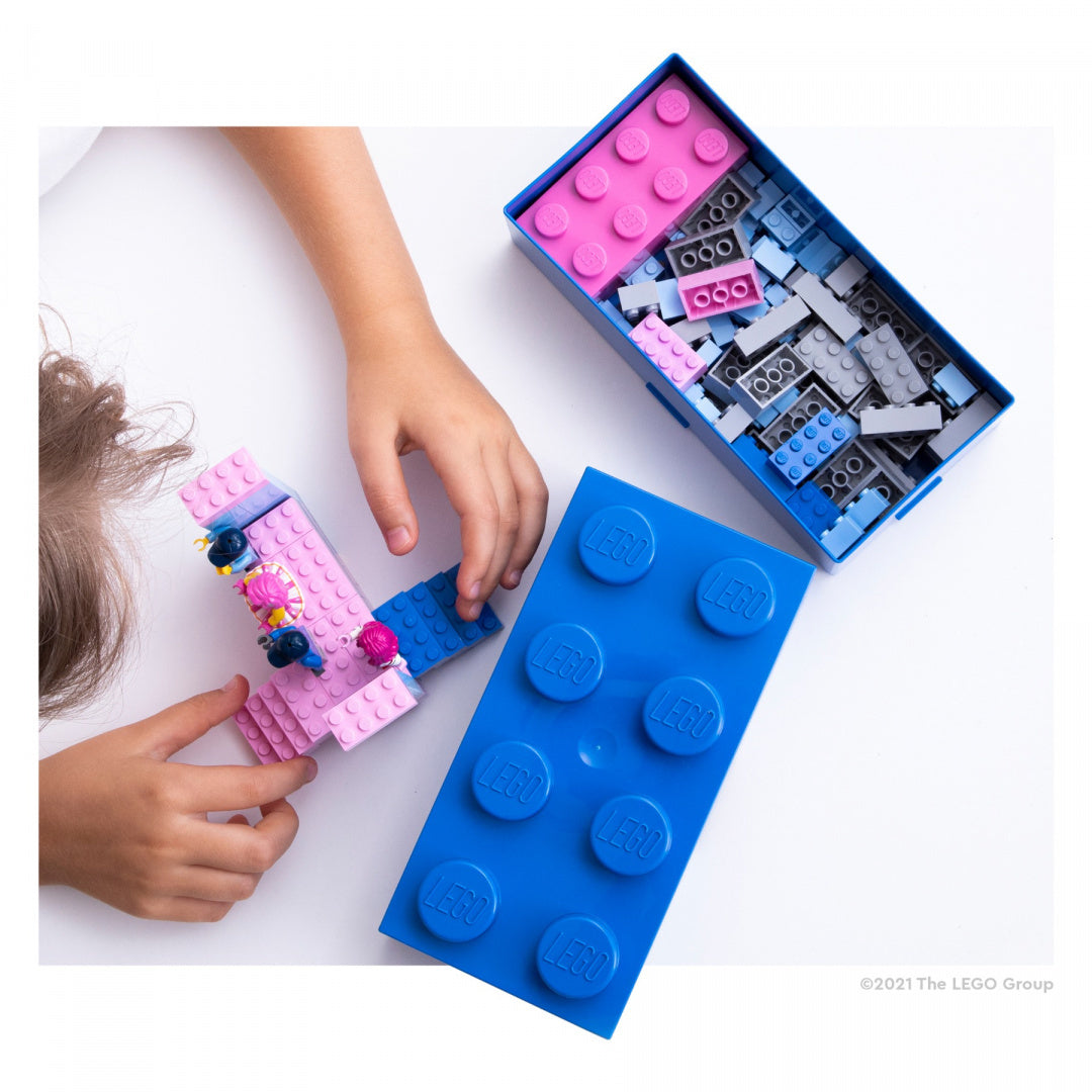 Dziecko bawi się klockami z lunchbox LEGO niebieski w kształcie dużej cegiełki LEGO