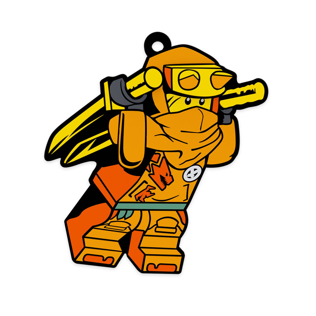 Kolorowy magnes LEGO Ninjago Arin przedstawiający pomarańczową postać ninja z mieczami