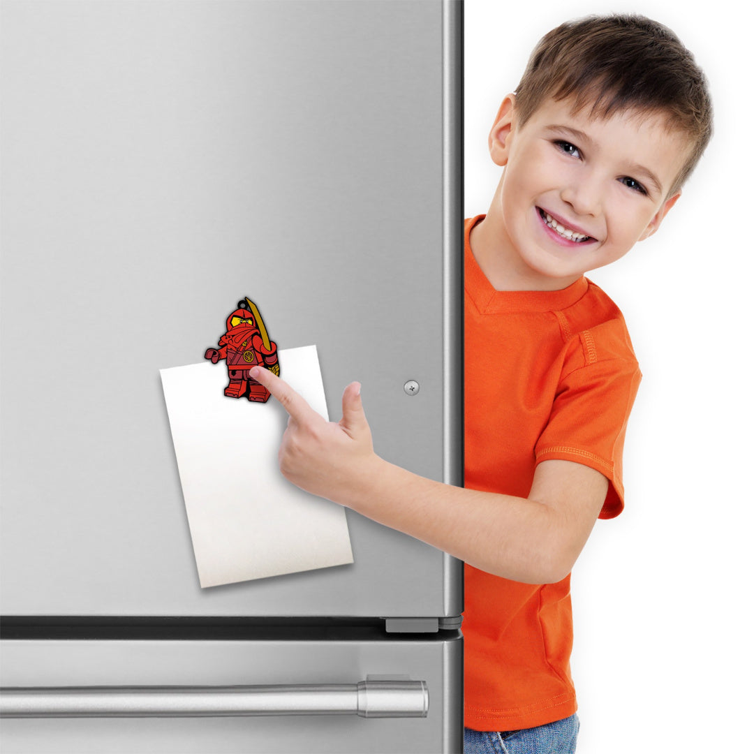 Chłopiec przy lodówce z magnesem LEGO Ninjago Kai trzymającym kartkę papieru
