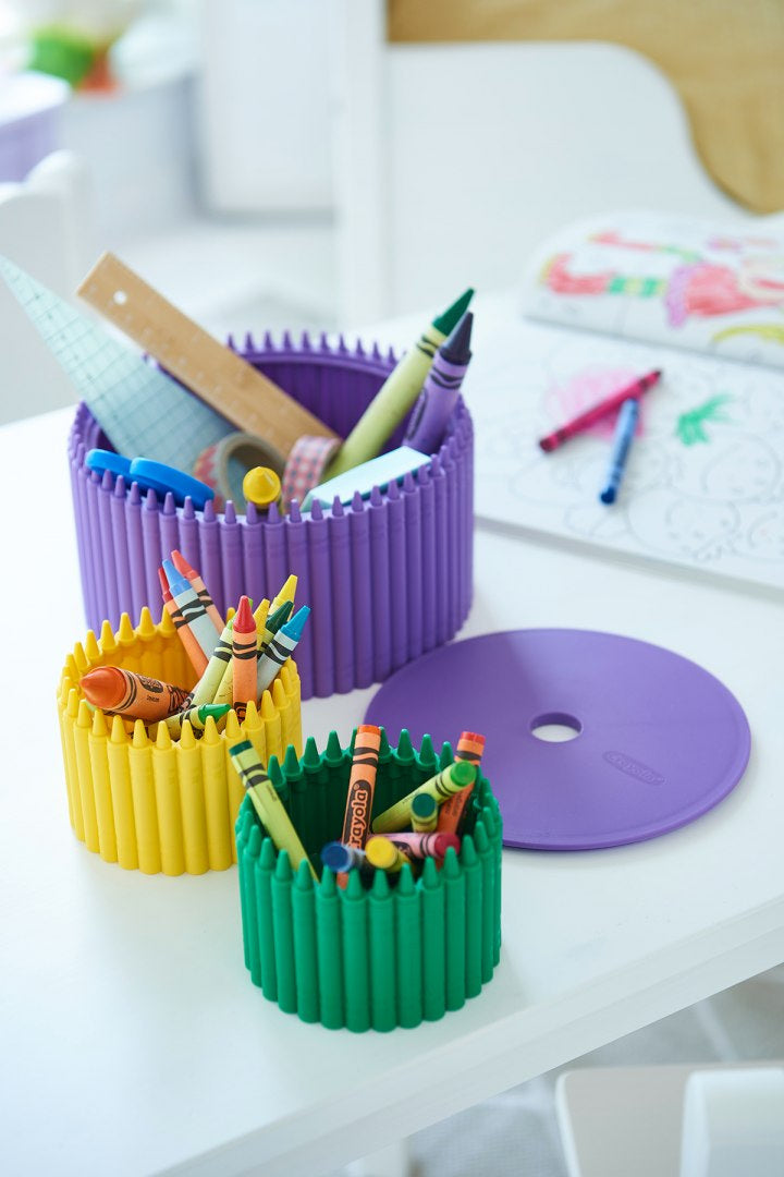 Przybornik Crayola fioletowy z kolorowymi kredkami i przyborami do pisania na białym stole