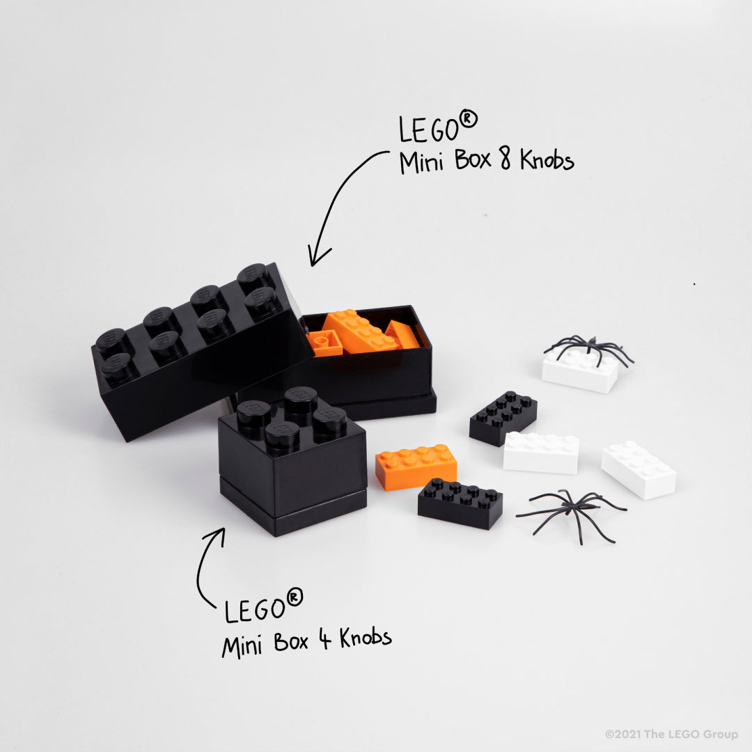 Czarne minipudełko LEGO czarne w kształcie klocka z pomarańczowymi elementami i małymi pająkami