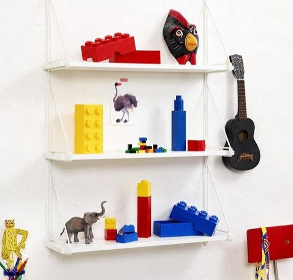 minipudełko LEGO 8 żółte umieszczone na białej półce z klockami i dekoracjami w pokoju dziecięcym