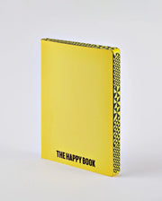 Żółty notatnik The Happy Book z czarnym wzorem na grzbiecie i napisem na okładce