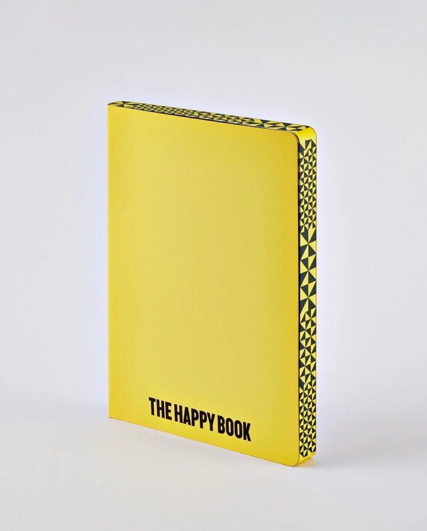 Żółty notatnik The Happy Book z czarnym wzorem na grzbiecie i napisem na okładce