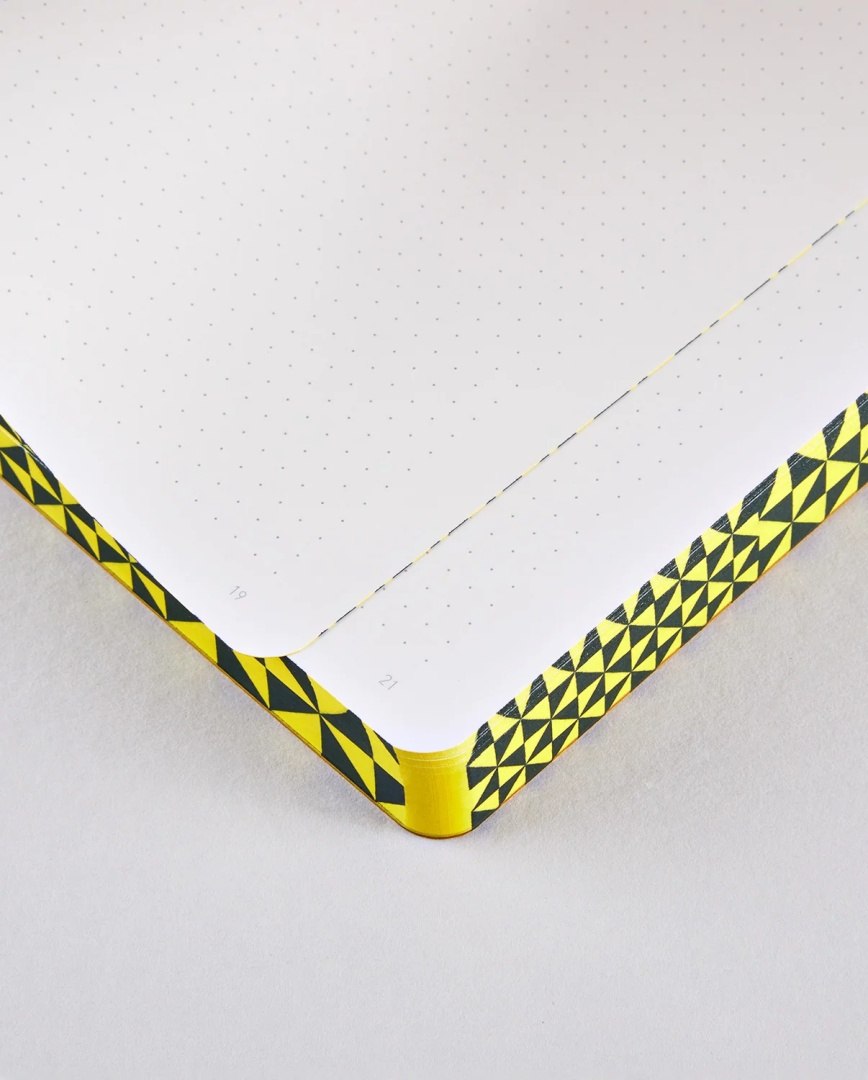Notatnik The Happy Book z kropkowanymi kartkami i żółto-czarną geometryczną oprawą