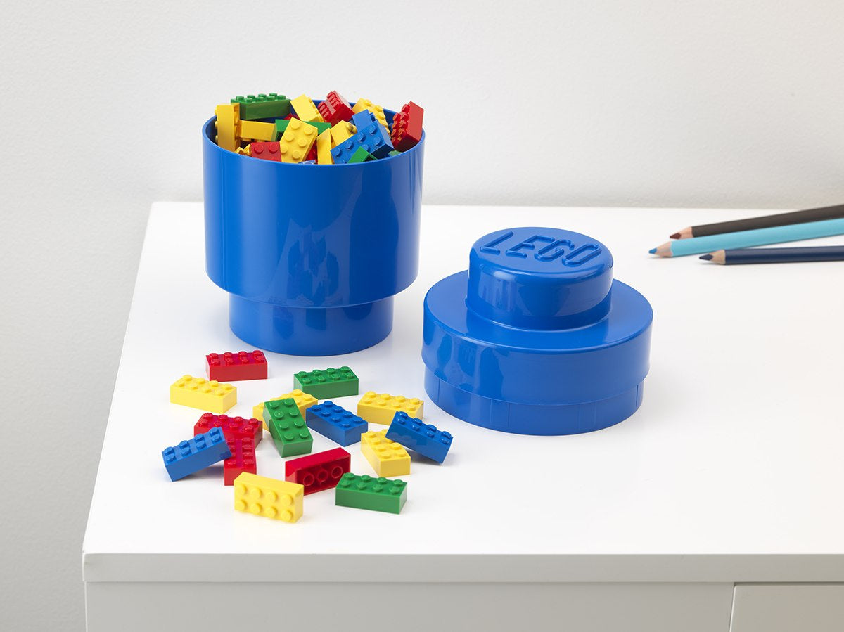 Pojemnik LEGO okrągły niebieski do przechowywania kolorowych klocków LEGO na białym blacie