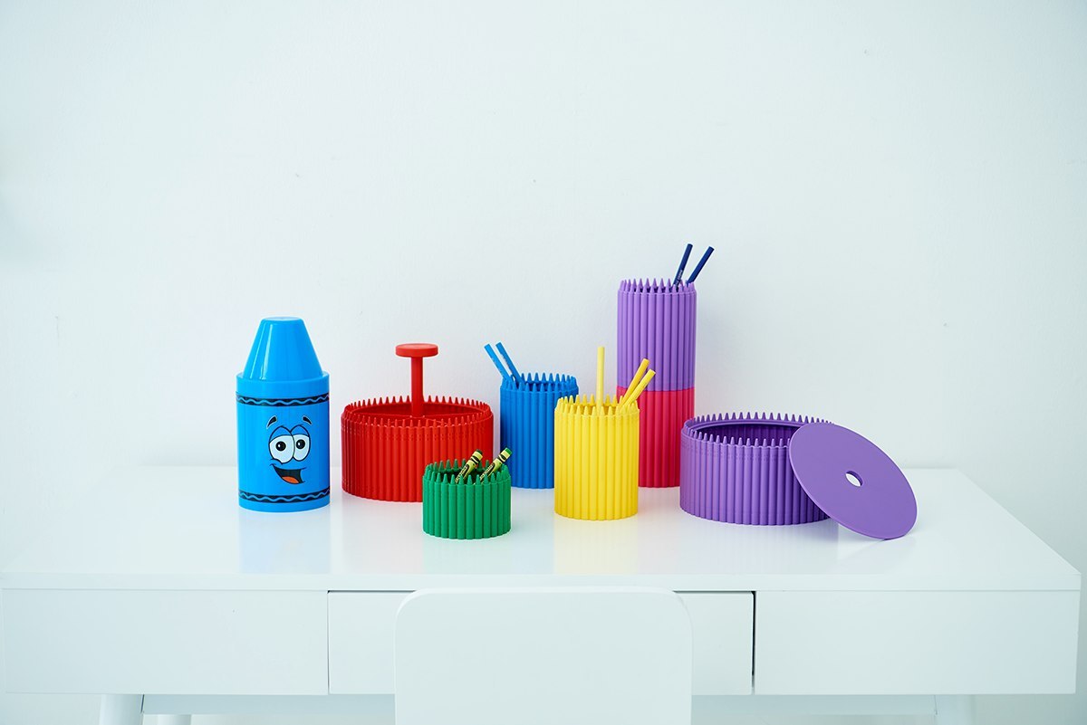 Organizer na biurko Crayola czerwony wraz z innymi kolorowymi organizerami na białym biurku