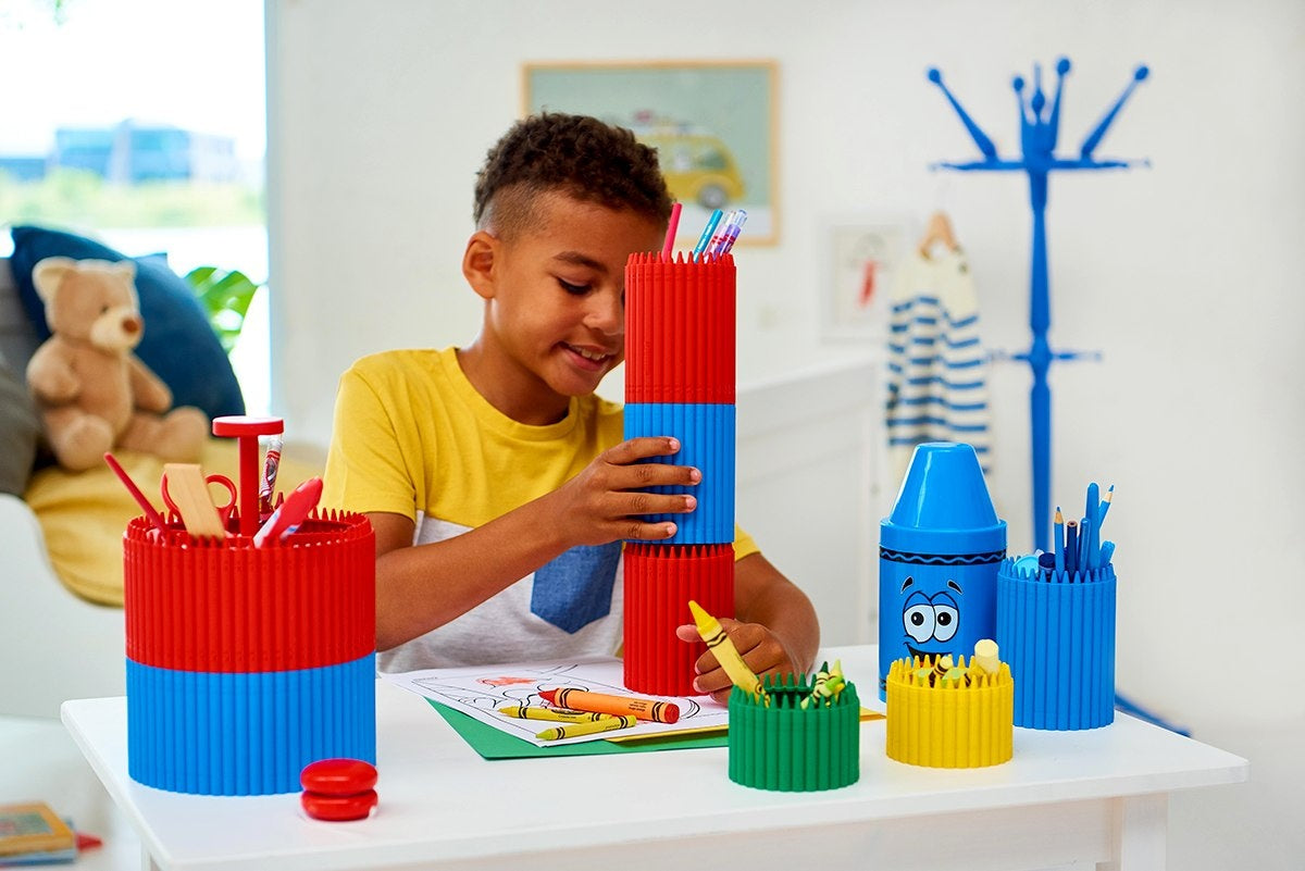 Organizery na biurko Crayola w różnych kolorach z kredkami i przyborami, chłopiec bawi się organizer na biurko Crayola fioletowy