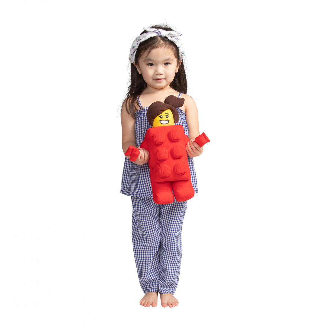 Dziecko trzymające pluszak LEGO Brick Suit Girl w czerwonym kostiumie klocka LEGO