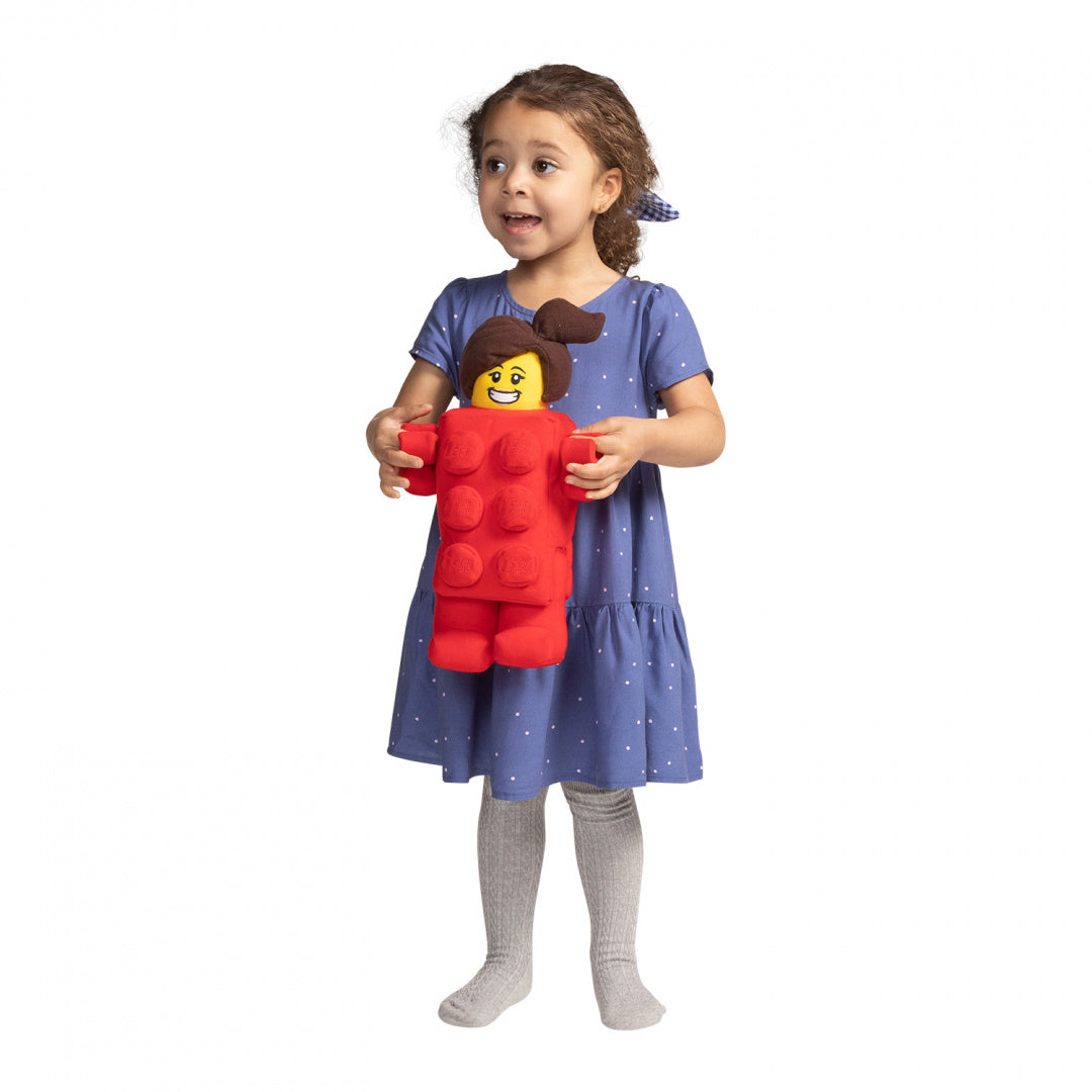 Dziewczynka trzymająca pluszak LEGO Brick Suit Girl w czerwonym kostiumie klocka LEGO