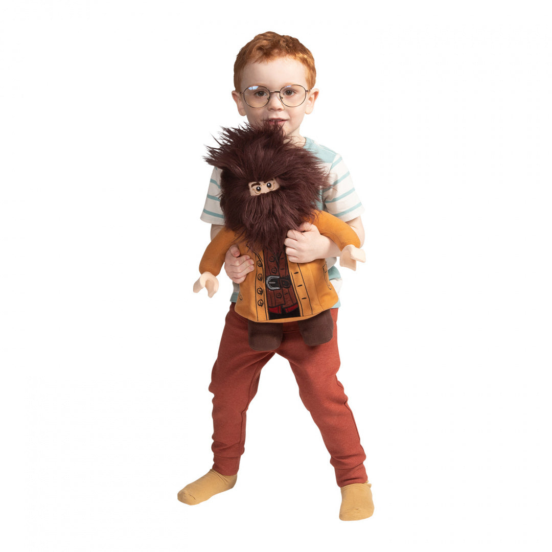 Dziecko trzymające pluszaka Hagrid Lego Harry Potter z dużą brązową brodą i pomarańczową kurtką