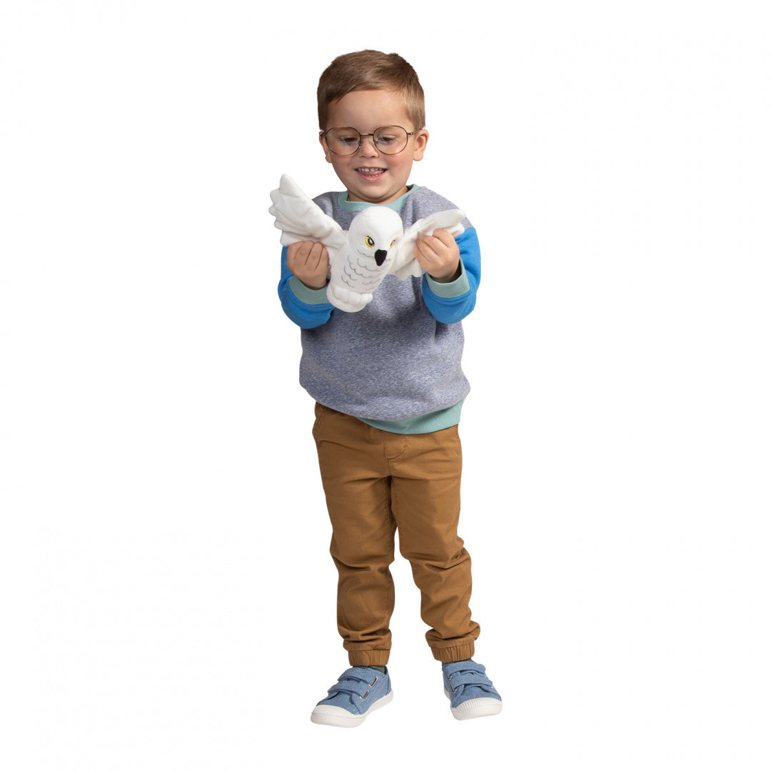 Dziecko bawiące się pluszakiem Hedwiga Harry Potter od LEGO miękka sowka na biały tle