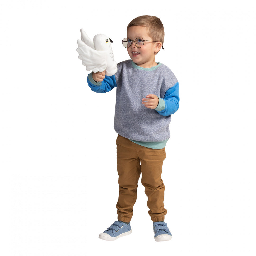 Dziecko bawiące się pluszakiem Hedwiga Harry Potter od LEGO® w kształcie białej sowy