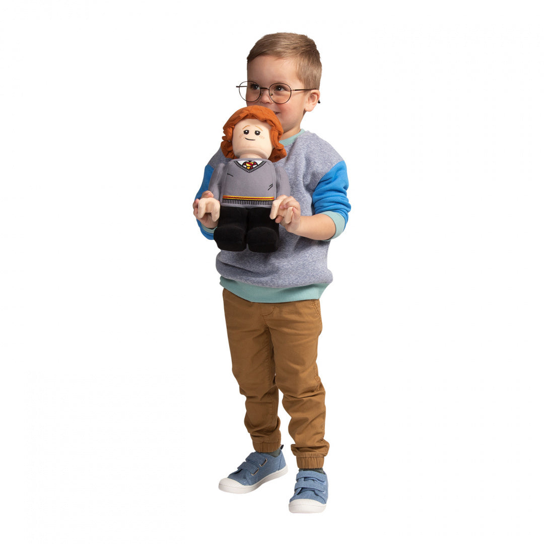 Dziecko trzymające pluszaka Ron Weasley LEGO z rudymi włosami w szarej bluzie