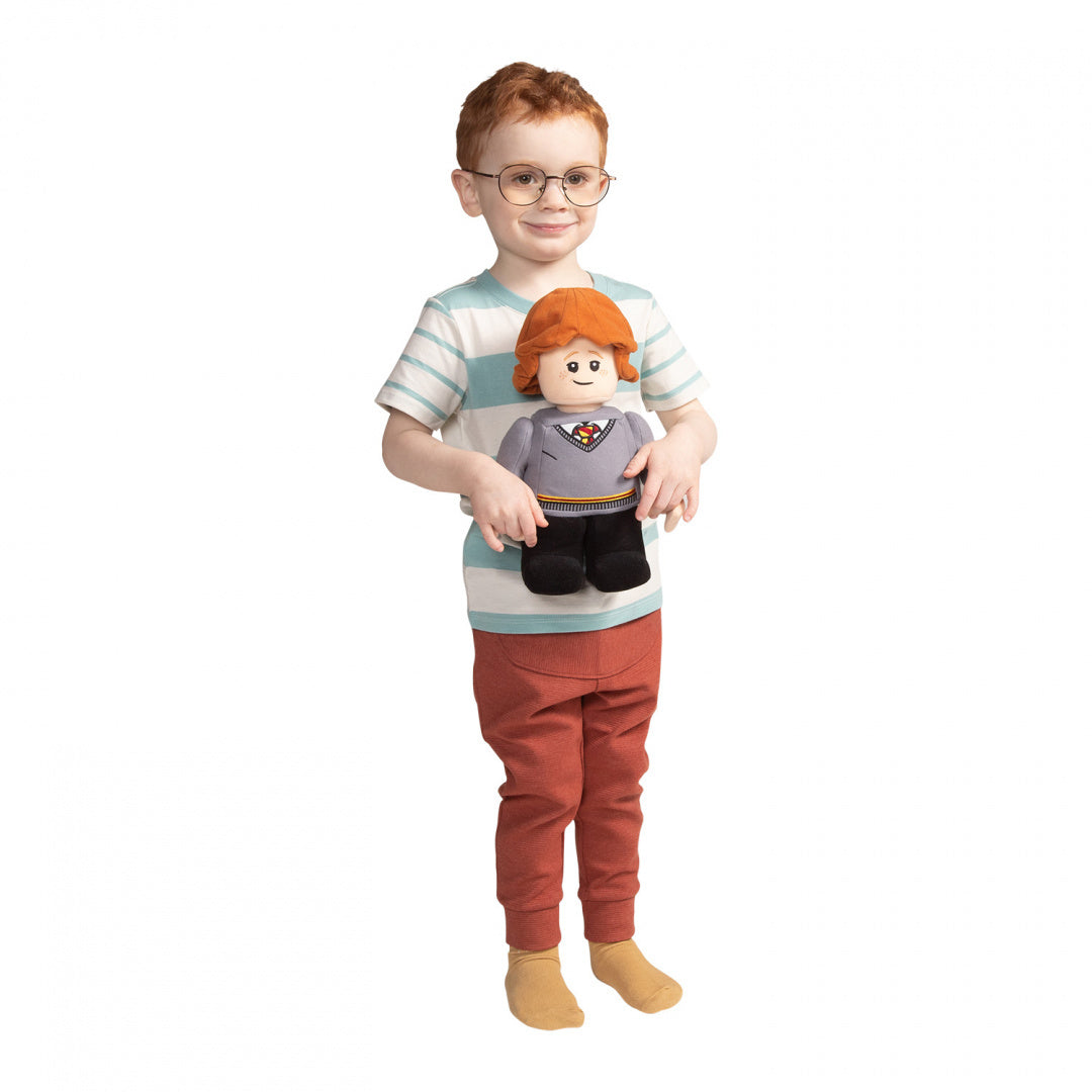 Dziecko trzymające pluszaka Ron Weasley LEGO w ubraniu inspirowanym Harrym Potterem