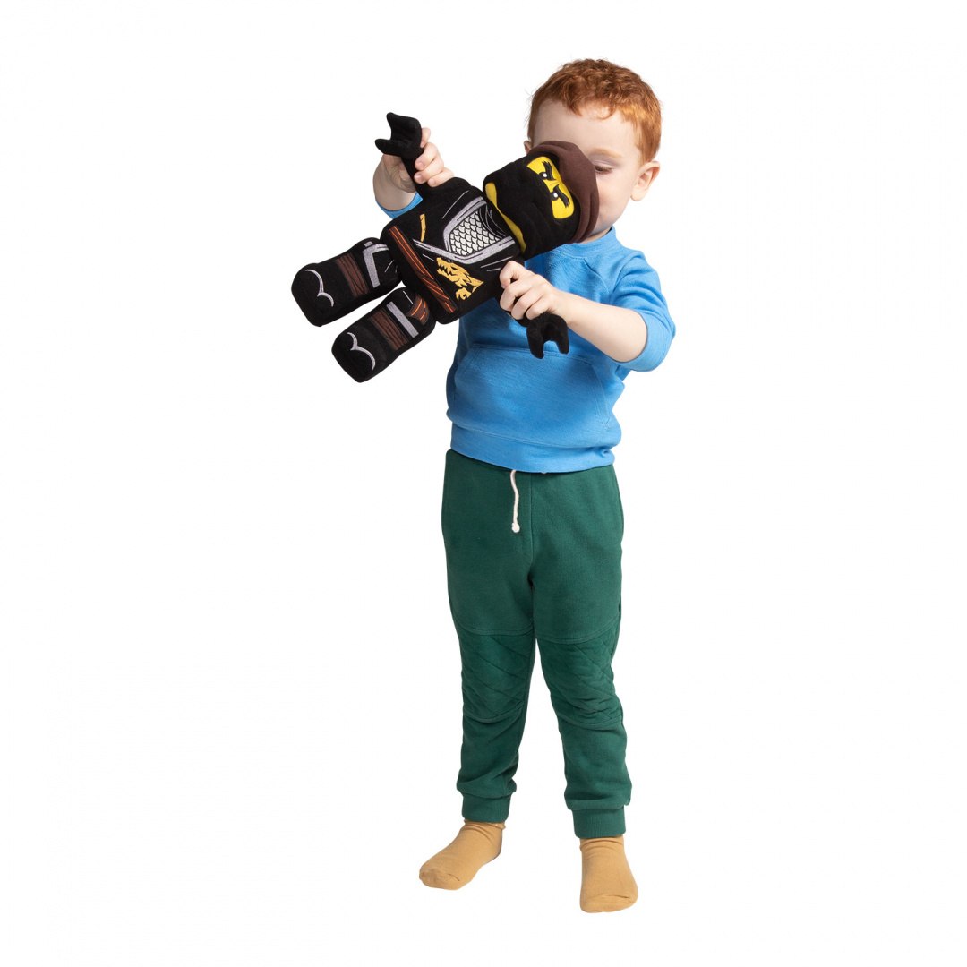 Chłopiec bawi się pluszakiem LEGO Ninjago Cole w czarnym stroju ninja