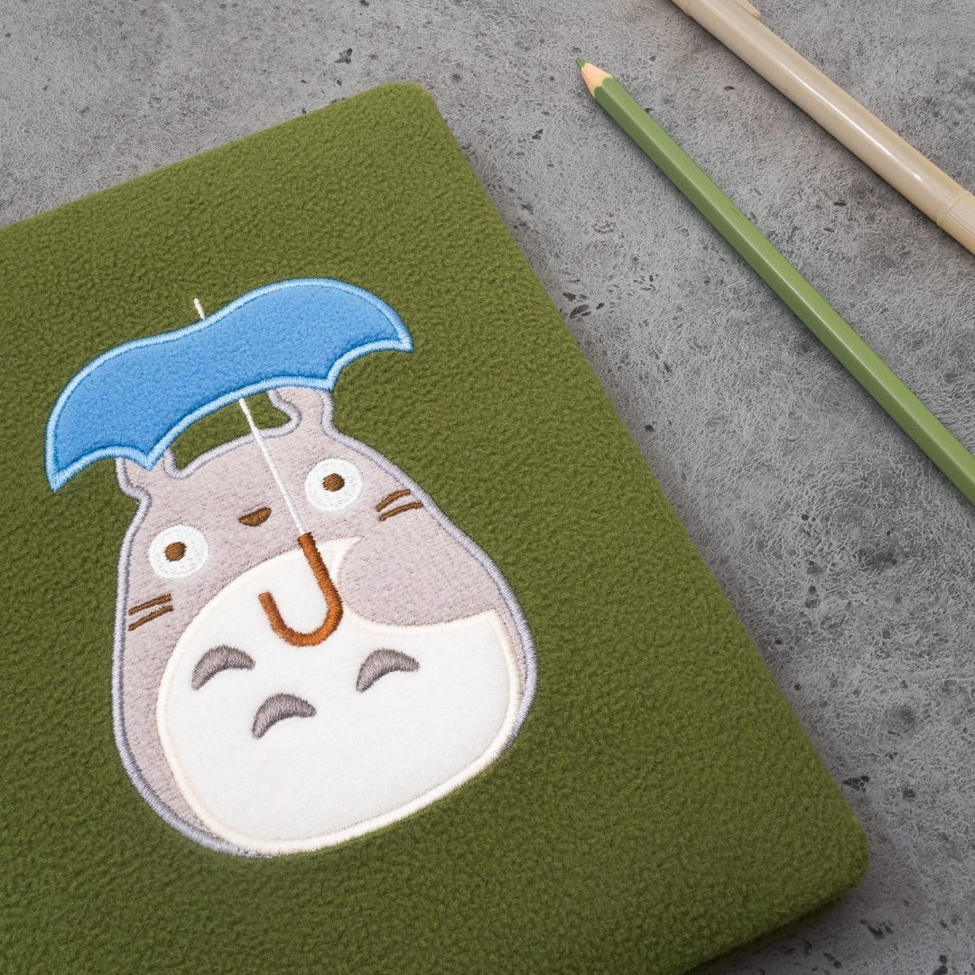 Zielony pluszowy notatnik Totoro z haftem postaci Totoro trzymającego niebieski parasol