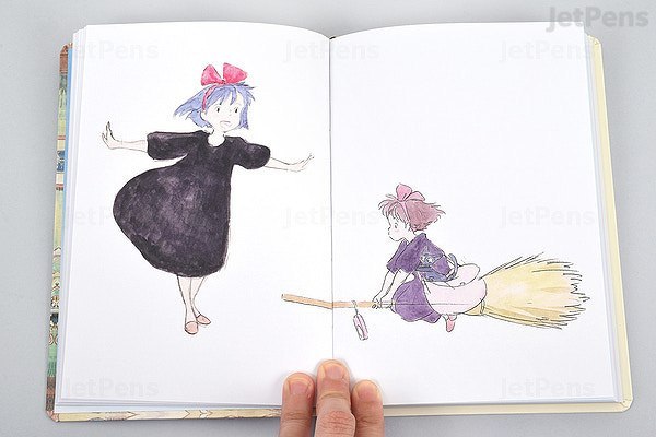 Otwarty notatnik Kiki Studio Ghibli z ilustracjami postaci Kiki i jej miotły
