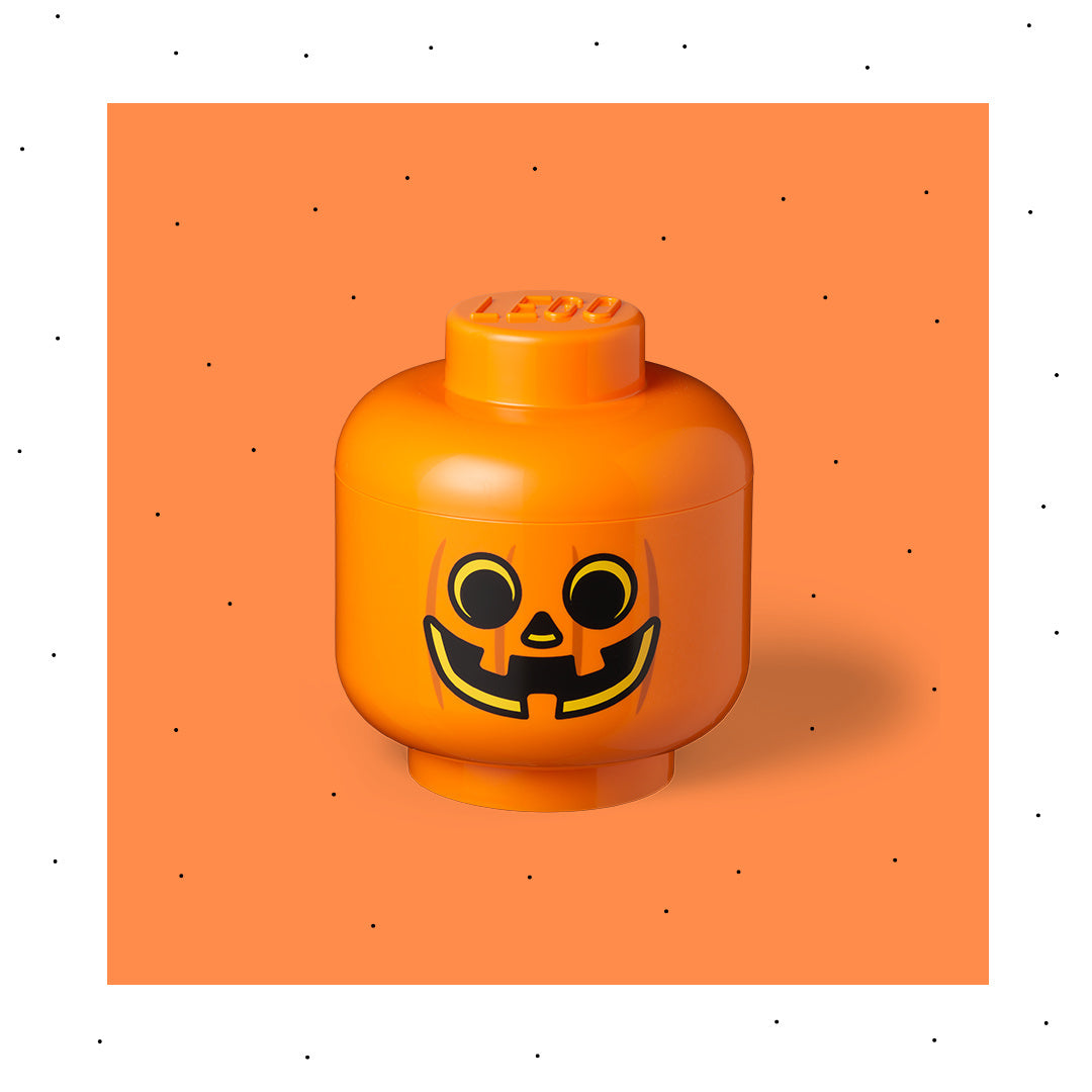 Pomarańczowy pojemnik LEGO dynia z nadrukiem dyniowego uśmiechu na pomarańczowym tle