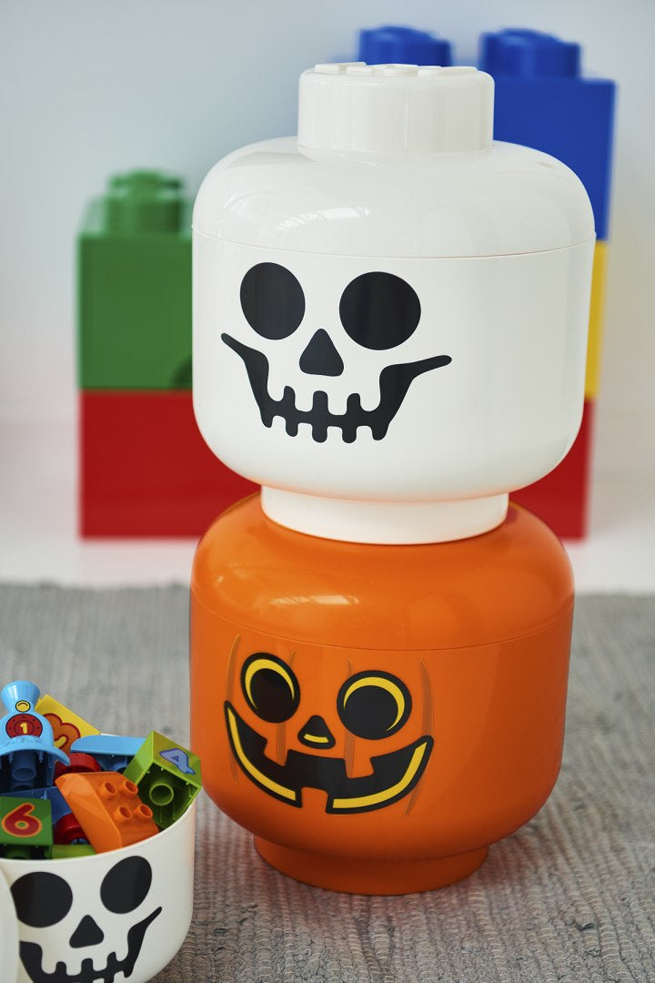 Pojemnik LEGO głowa szkieletor biały z czarnym nadrukiem czaszki na tle kolorowych klocków