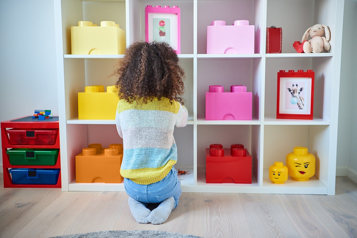Pojemnik LEGO Brick 4 jasnoróżowy na półce w pokoju dziecięcym obok innych kolorowych pojemników