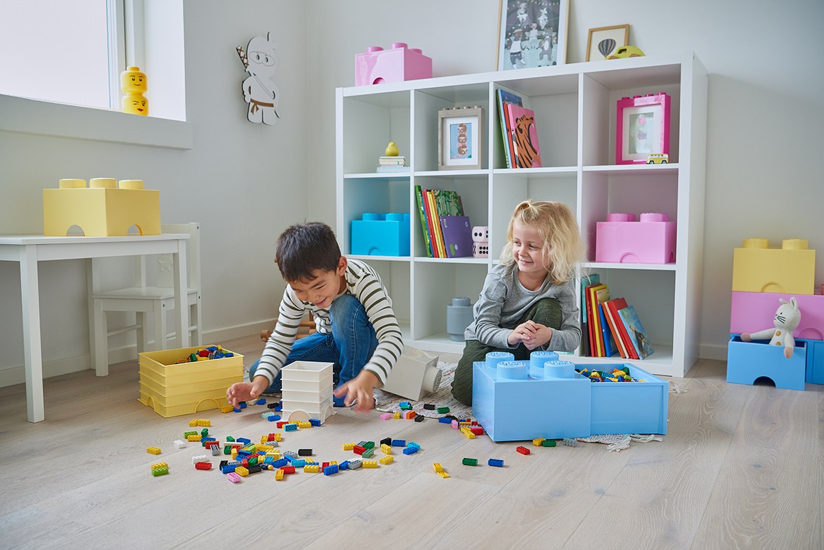 Dzieci bawiące się klockami LEGO z pojemnikiem LEGO Brick 4 jasnoróżowy na półce w pokoju zabaw