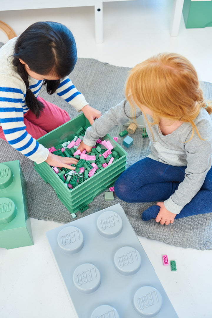 Dzieci bawiące się zabawką z pojemnikiem LEGO Brick 8 szary pełnym kolorowych klocków LEGO