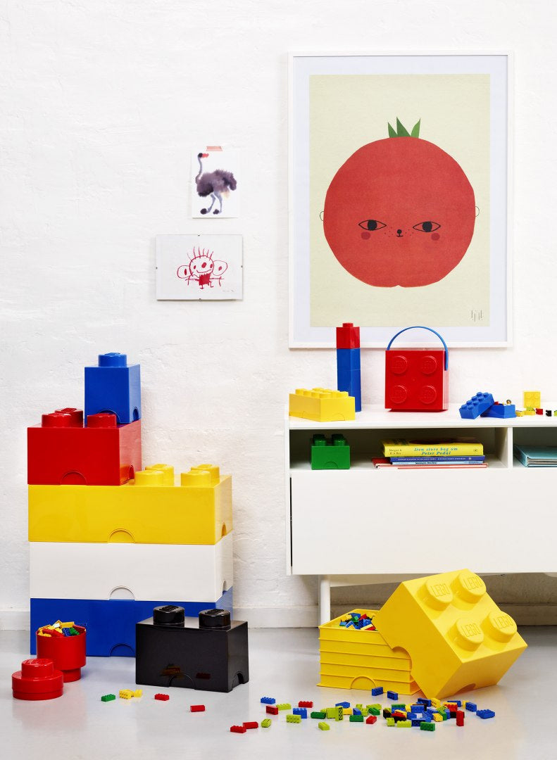 Pojemnik LEGO na klocki w różnych kolorach umieszczony w pokoju dziecięcym z rozrzuconymi klockami LEGO