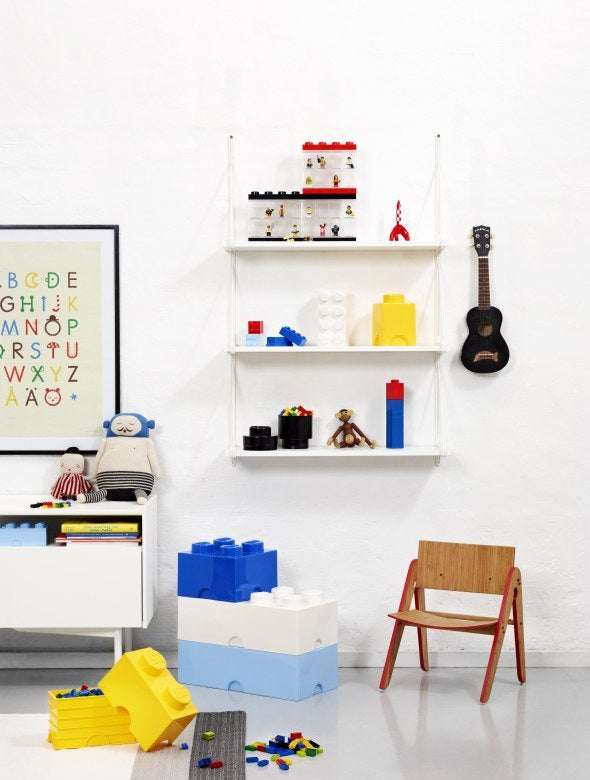 Pojemnik LEGO na klocki w kształcie dużych klocków w kolorach niebieskim, białym i żółtym w pokoju dziecięcym