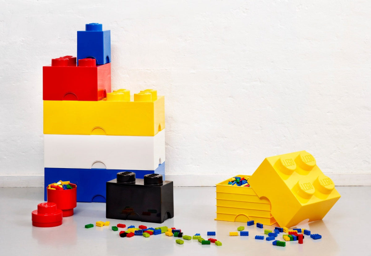 Pojemnik LEGO Brick 2 czarny w otoczeniu dużych kolorowych pojemników i rozrzuconych klocków LEGO