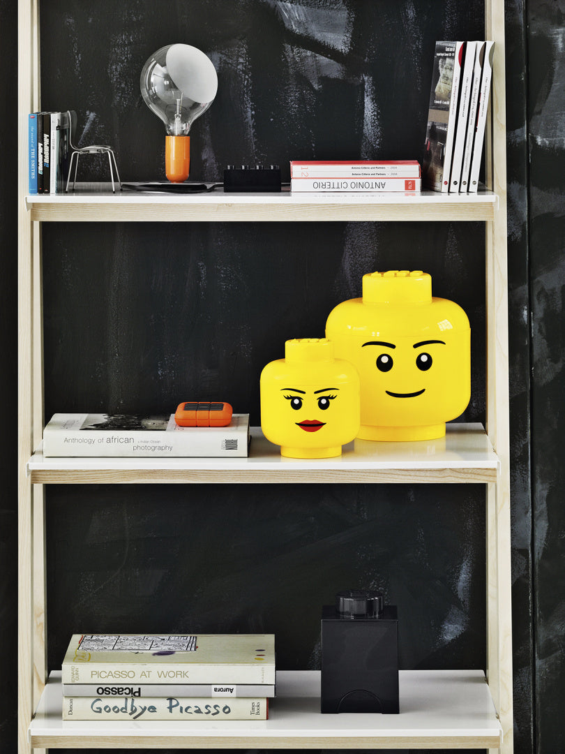 Pojemnik LEGO głowa dziewczynka i pojemnik LEGO głowa chłopiec w kolorze żółtym na półce