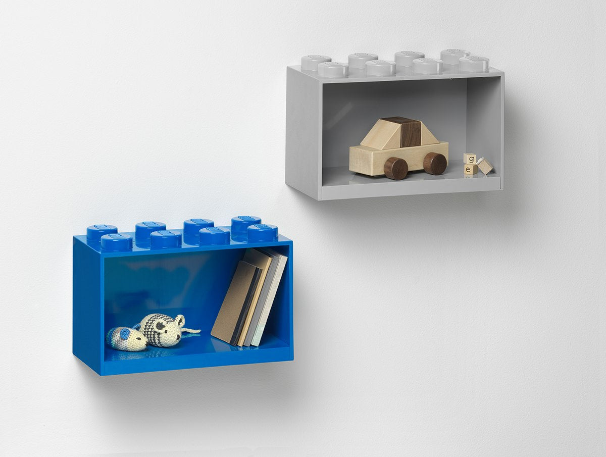 Szara półka LEGO BRICK 8 szara zamontowana na ścianie z drewnianą zabawką samochodu i niebieska półka z książkami