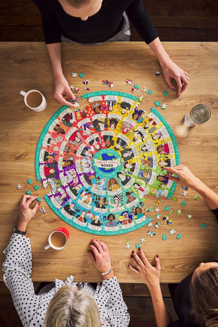 Puzzle inspirujące kobiety 1000 elementów układane przez cztery osoby przy drewnianym stole