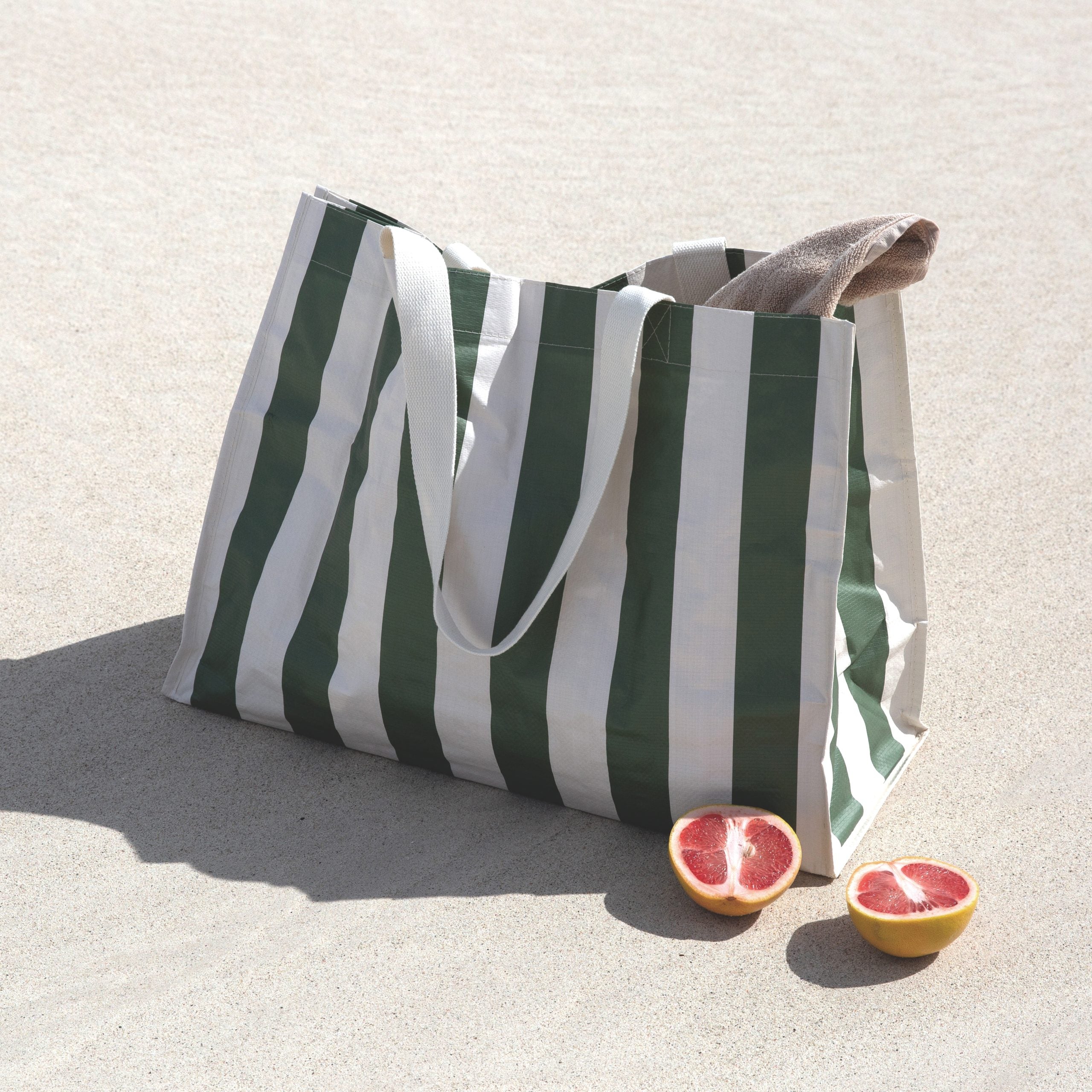 SUNNY LIFE torba plażowa w oliwkowe pasy z białymi paskami na piasku z ręcznikiem i grejpfrutem