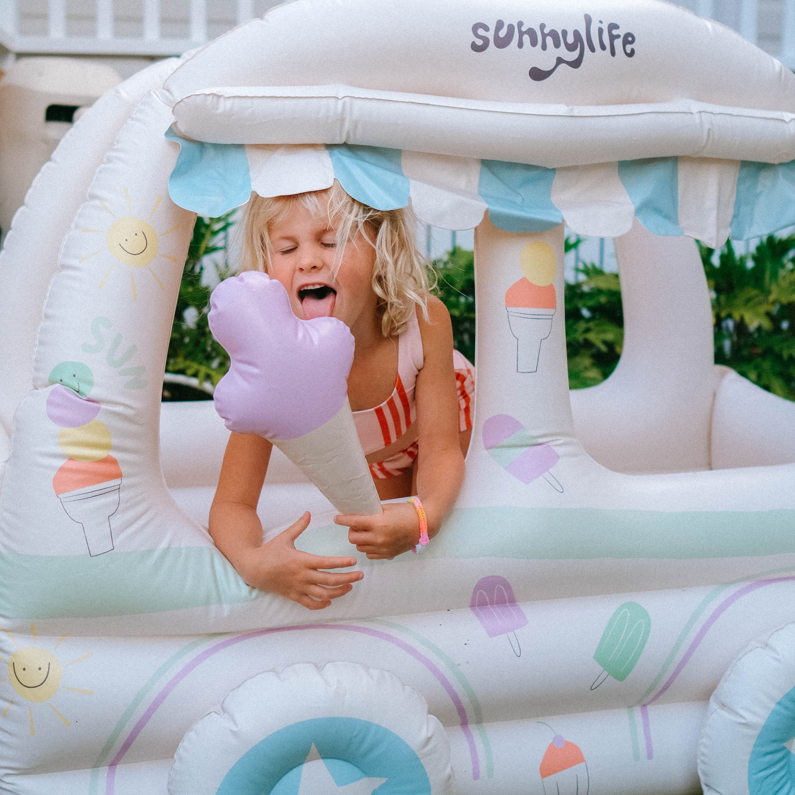 Nadmuchiwany domek dla dzieci marki SUNNY LIFE z pastelowymi wzorami i dziewczynką bawiącą się
