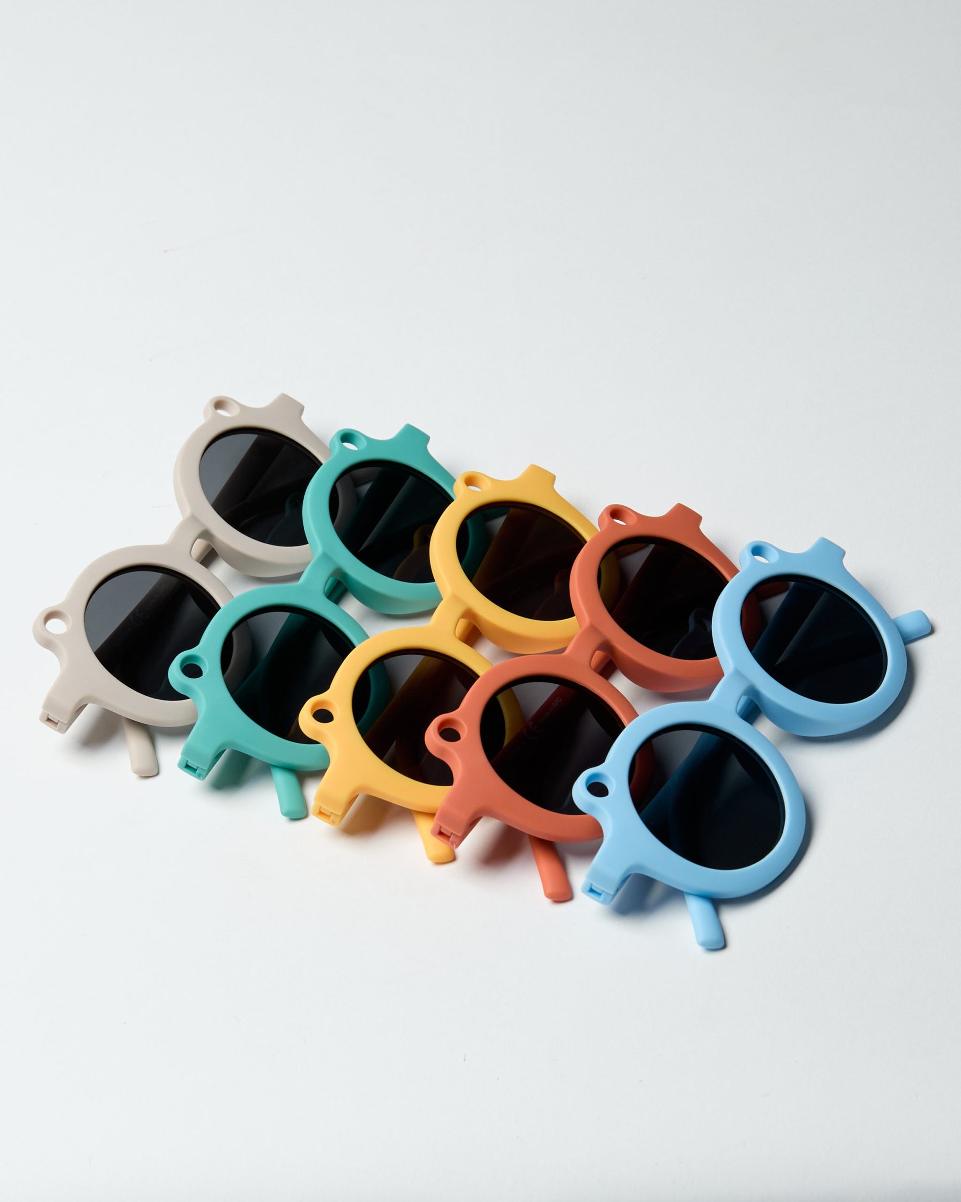 Kolorowe okulary przeciwsłoneczne dla dzieci od BV JACOB COMPANY w różnych odcieniach na białym tle