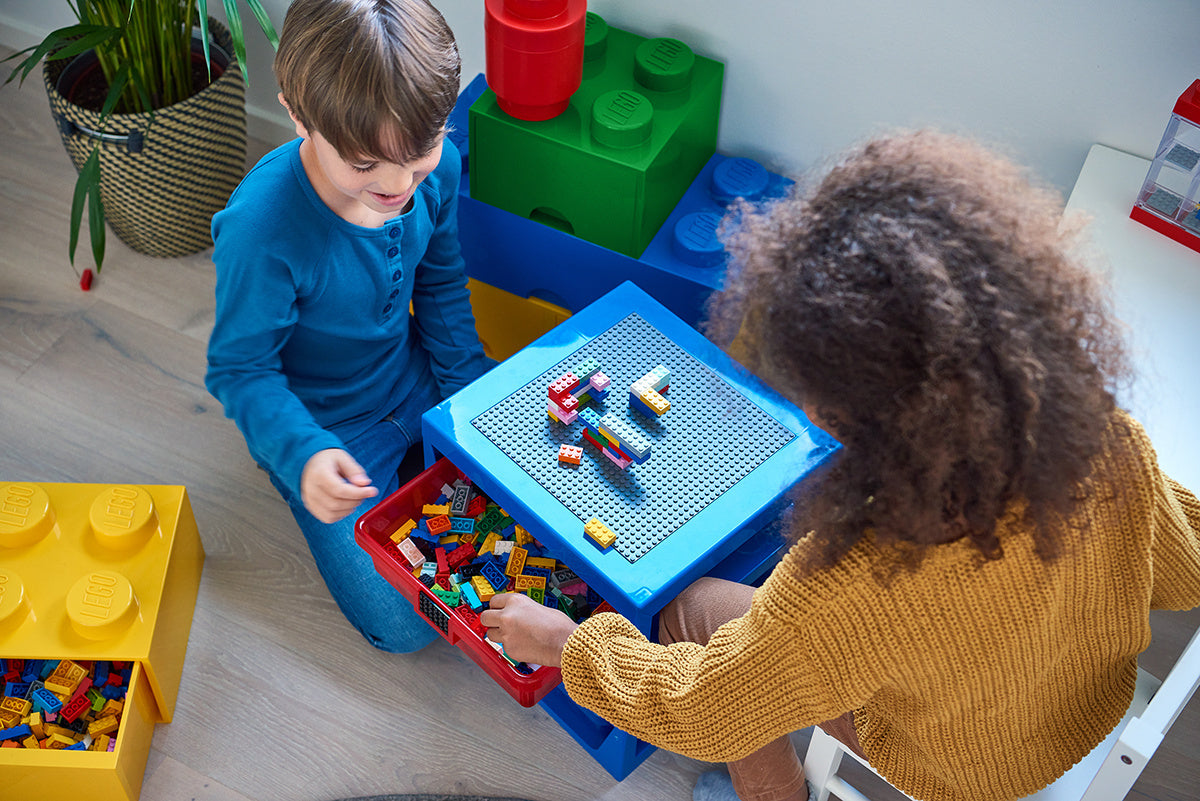 Dzieci bawiące się zestawem LEGO z niebieską szufladą klocek LEGO i klockami na stole